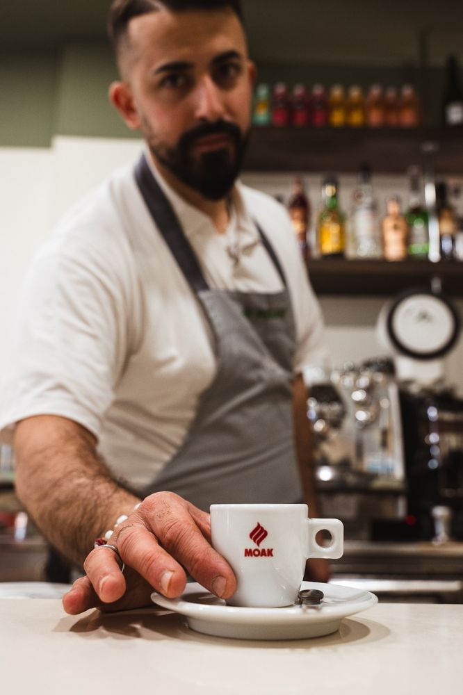 Saverio serve un caffè al bancone di Bianca Cafè